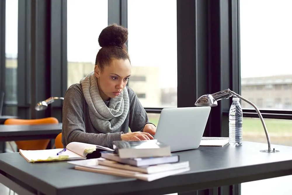 woman-using-laptop-for-taking-notes-to-study-P7EJLNK